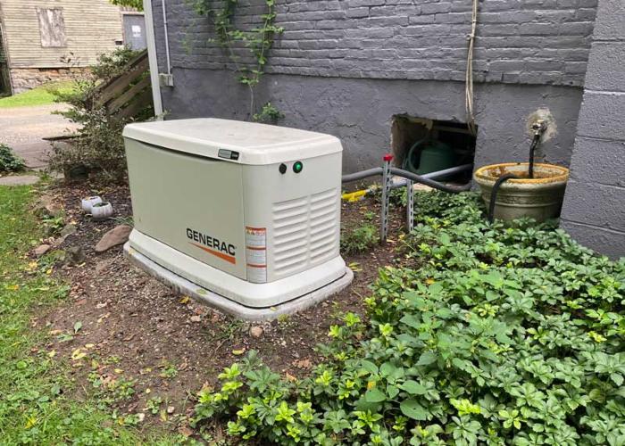 Technician servicing a Generac generator with tools and diagnostic equipment in Blairstown, NJ