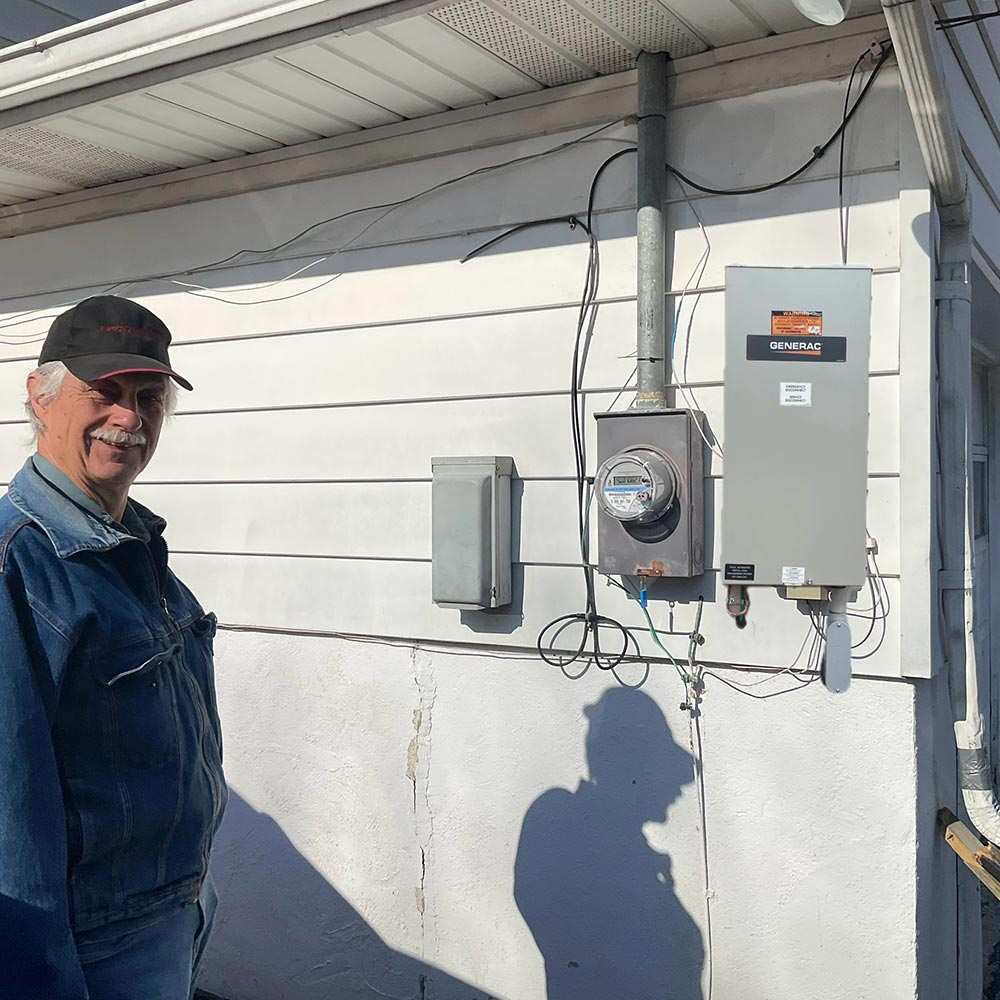 A man standing by a Generac system, featuring a generator installation in Blairstown, NJ