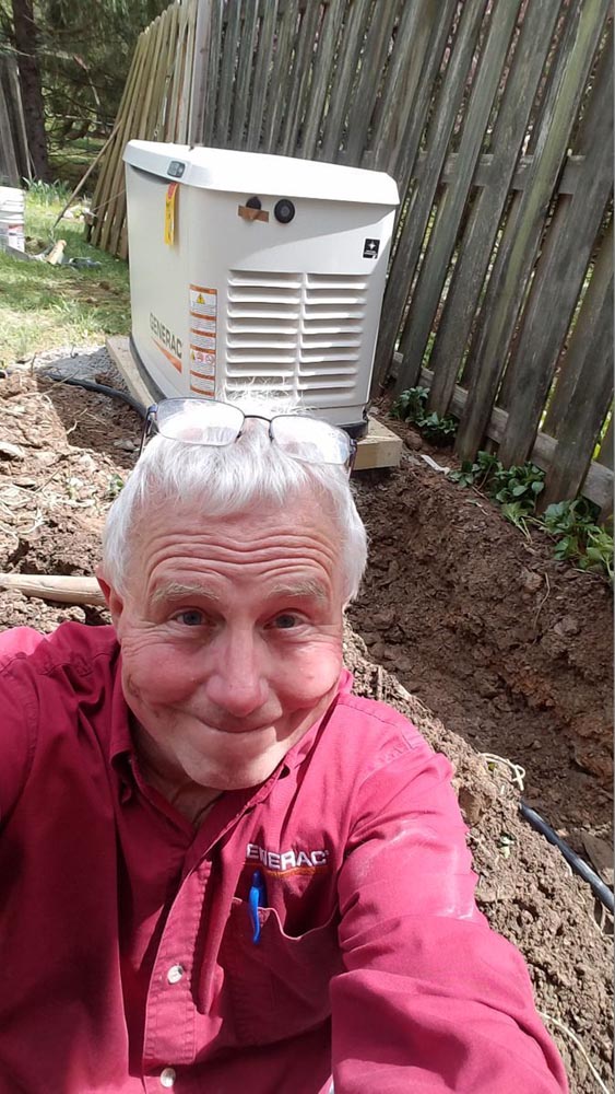 employee taking a selfie by a newly installed generator