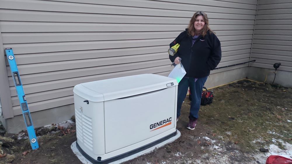 woman standing next to newly installed generator outside home