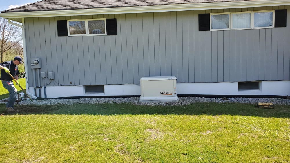 generator outside home with gray walls