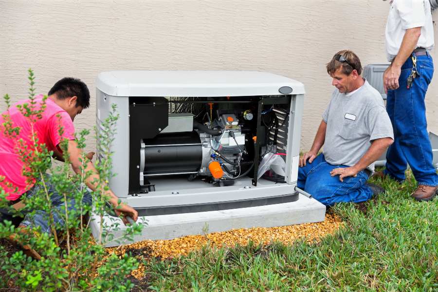 Three Technicians engaged in Generator Repair Work in a Yard in Blairstown, NJ
